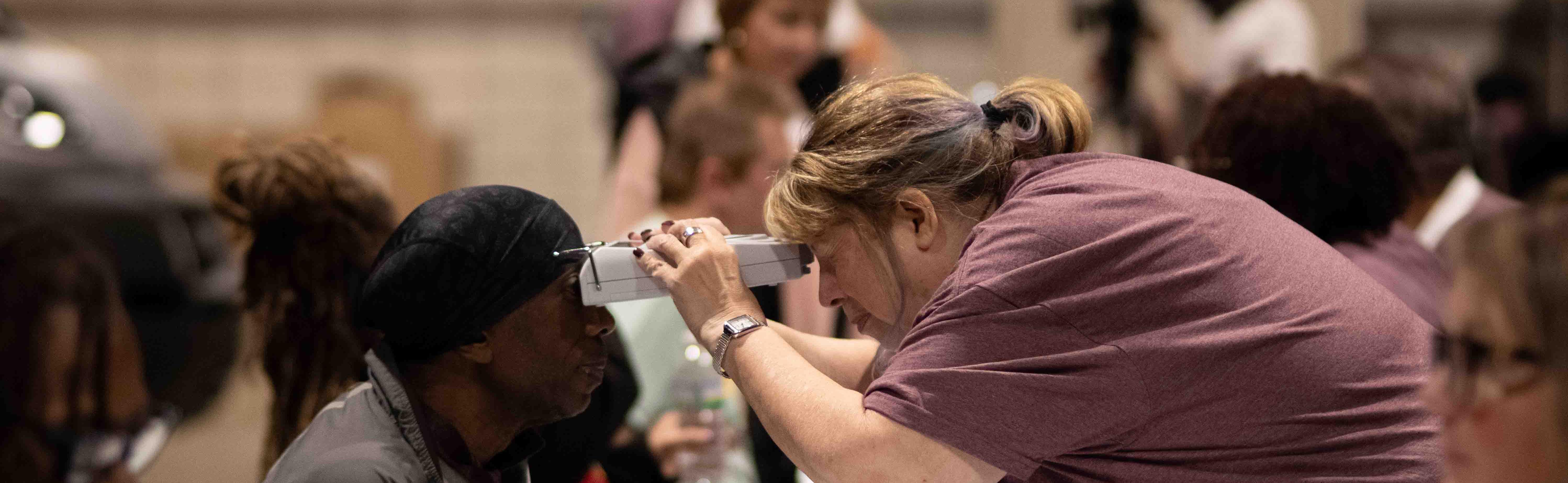 Woman giving a patient an eye exam